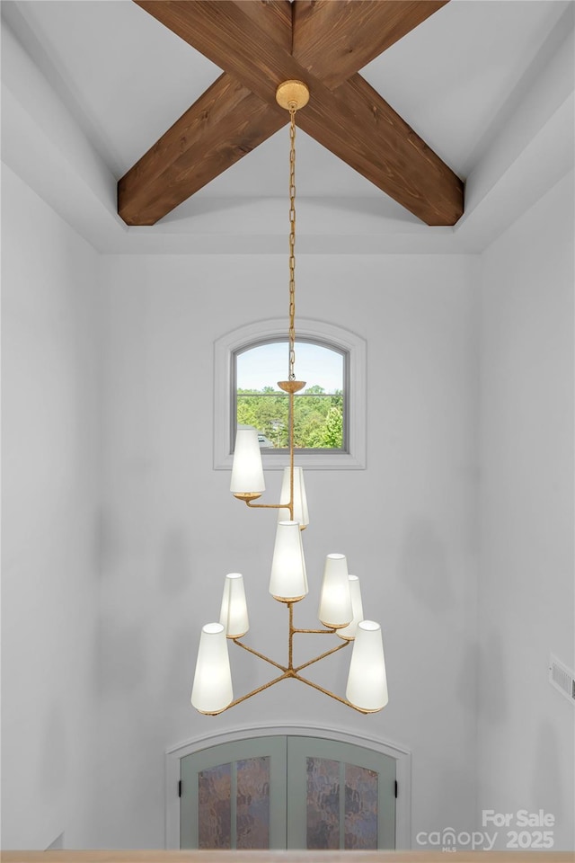 interior details featuring visible vents, a chandelier, and beam ceiling