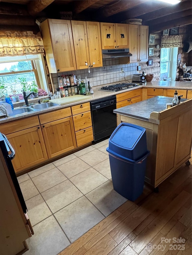 kitchen featuring under cabinet range hood, stainless steel gas cooktop, black dishwasher, a sink, and tasteful backsplash