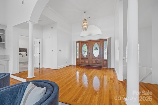 16108 Woolwine Rd, Charlotte, NC 28278 - foyer entrance with ornate columns, crown molding, wood finished floors, baseboards, and arched walkways