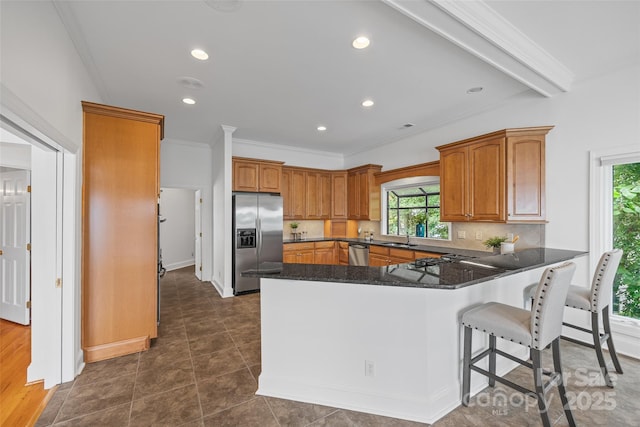 16108 Woolwine Rd, Charlotte, NC 28278 - kitchen with appliances with stainless steel finishes, a peninsula, a sink, a kitchen breakfast bar, and brown cabinetry