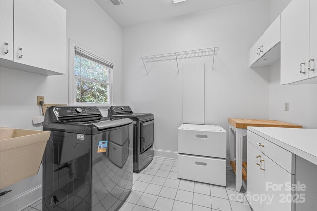 16108 Woolwine Rd, Charlotte, NC 28278 - laundry area with washer and dryer, cabinet space, and light tile patterned flooring