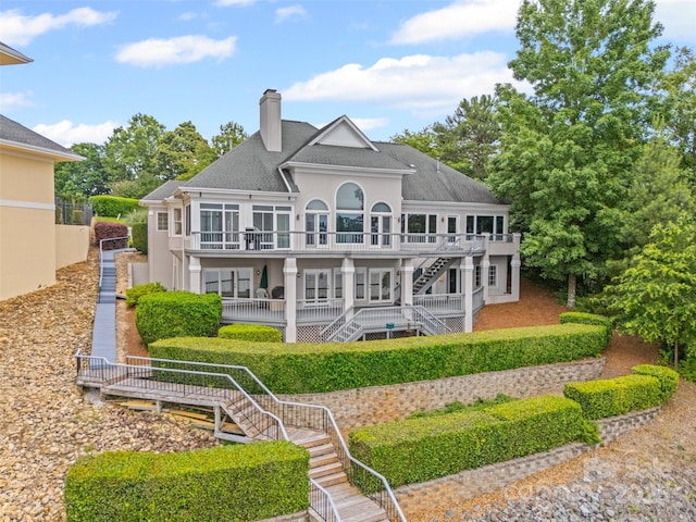 16108 Woolwine Rd, Charlotte, NC 28278 - back of property with stairs, a chimney, a balcony, a shingled roof, and stucco siding