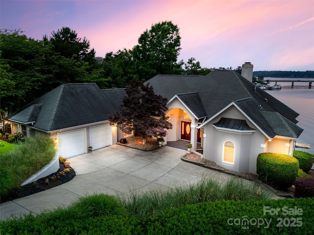 16108 Woolwine Rd, Charlotte, NC 28278 - view of front of property featuring an attached garage, a shingled roof, stucco siding, driveway, and a chimney