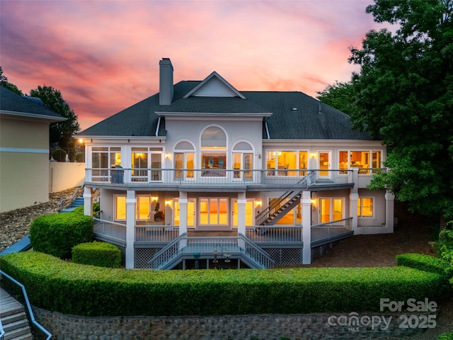16108 Woolwine Rd, Charlotte, NC 28278 - back of property at dusk with stairway, a chimney, a balcony, and roof with shingles