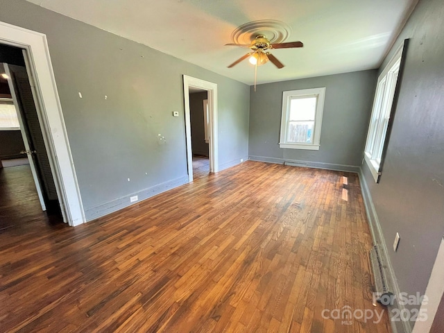 unfurnished bedroom with baseboards, ceiling fan, hardwood / wood-style floors, and visible vents