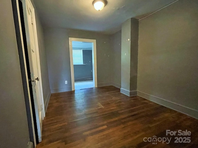 unfurnished room with baseboards and wood finished floors