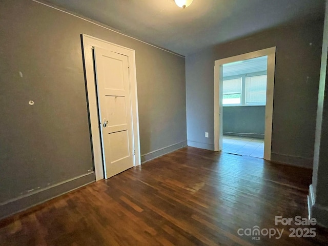 empty room featuring wood finished floors and baseboards
