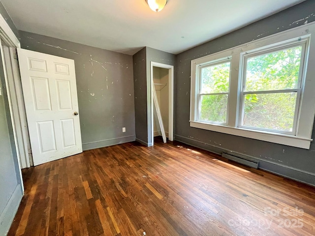 unfurnished bedroom with baseboards and wood finished floors