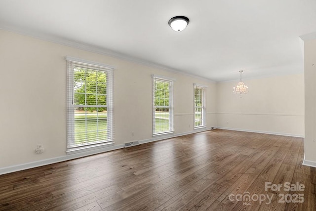 12117 Idlewild Rd, Matthews, NC 28105 - unfurnished room featuring a chandelier, ornamental molding, wood finished floors, and baseboards