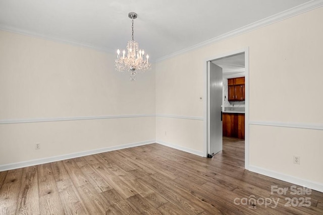 12117 Idlewild Rd, Matthews, NC 28105 - unfurnished dining area with a chandelier, wood finished floors, crown molding, and baseboards
