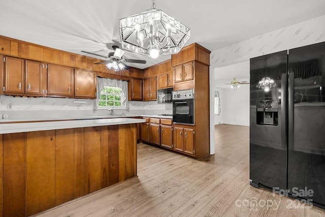 12117 Idlewild Rd, Matthews, NC 28105 - kitchen featuring black appliances, ceiling fan, brown cabinetry, and light countertops