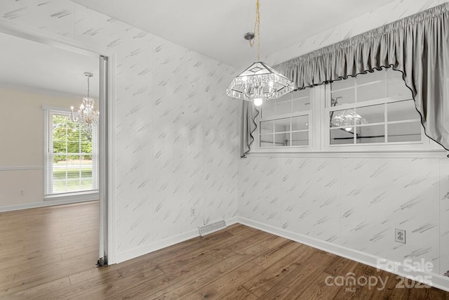 12117 Idlewild Rd, Matthews, NC 28105 - unfurnished dining area featuring a chandelier, wallpapered walls, and baseboards