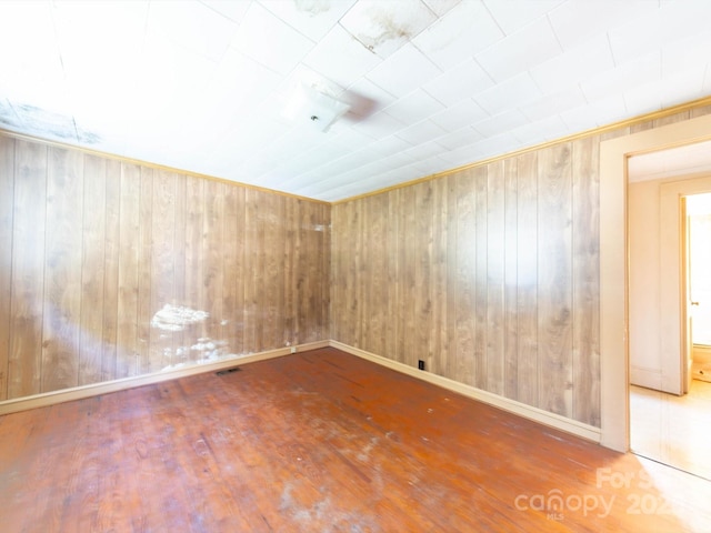 1470 Hilltop St, Albemarle, NC 28001 - empty room with wooden walls, visible vents, and wood finished floors