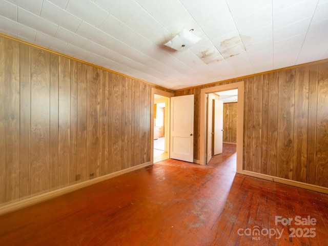 1470 Hilltop St, Albemarle, NC 28001 - spare room with hardwood / wood-style flooring, wooden walls, and baseboards