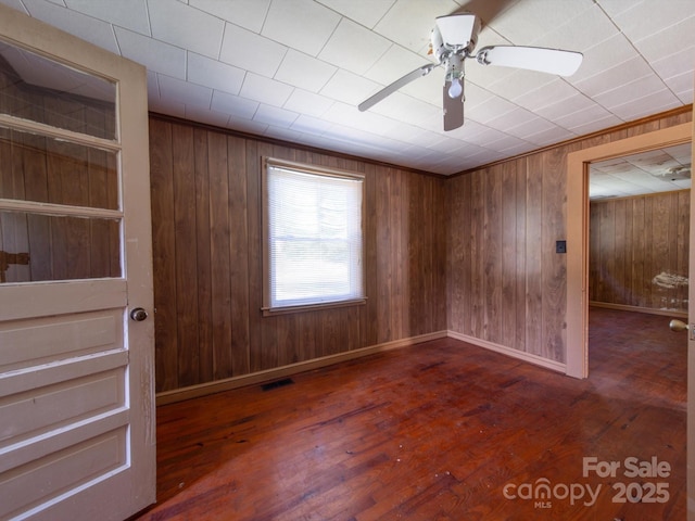 1470 Hilltop St, Albemarle, NC 28001 - spare room with wood walls, ceiling fan, visible vents, and hardwood / wood-style flooring