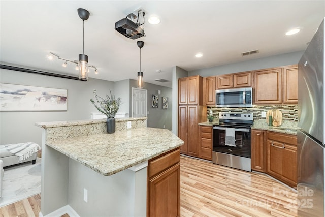 10421 Columbia Crest Ct, Charlotte, NC 28270 - kitchen featuring stainless steel appliances, light wood-style flooring, a center island, light stone counters, and recessed lighting