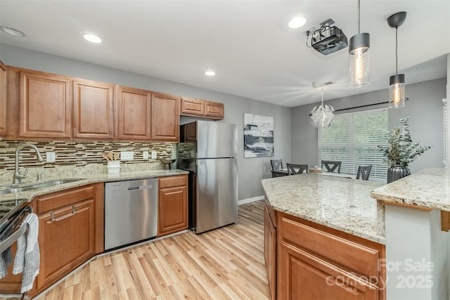 10421 Columbia Crest Ct, Charlotte, NC 28270 - kitchen featuring appliances with stainless steel finishes, light wood-style flooring, backsplash, light stone countertops, and hanging light fixtures