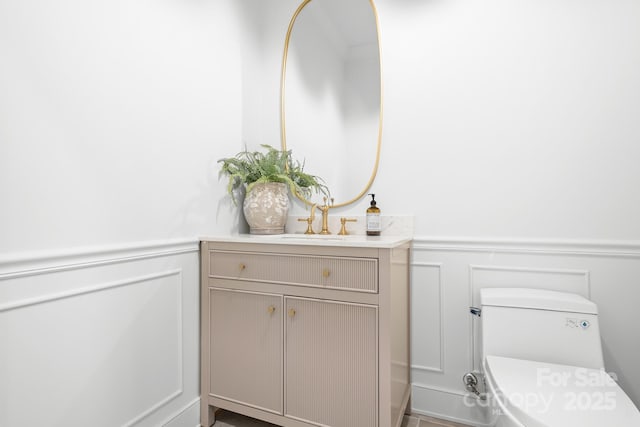 4316 Old Saybrook Ct, Charlotte, NC 28211 - half bathroom featuring a decorative wall, a wainscoted wall, vanity, and toilet