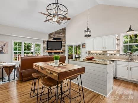 55 Christine Ct, Waynesville, NC 28786 - kitchen with white cabinetry, a chandelier, open floor plan, and high vaulted ceiling