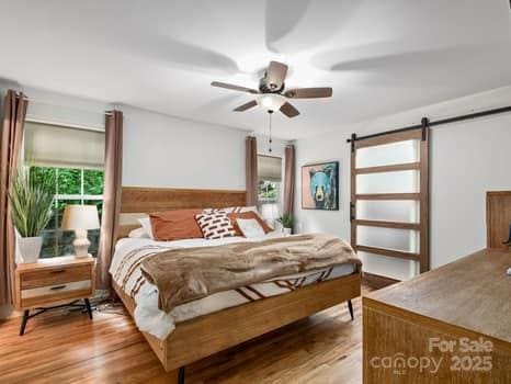 55 Christine Ct, Waynesville, NC 28786 - bedroom featuring a barn door and light wood finished floors