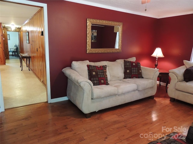 living room with crown molding, baseboards, and wood finished floors