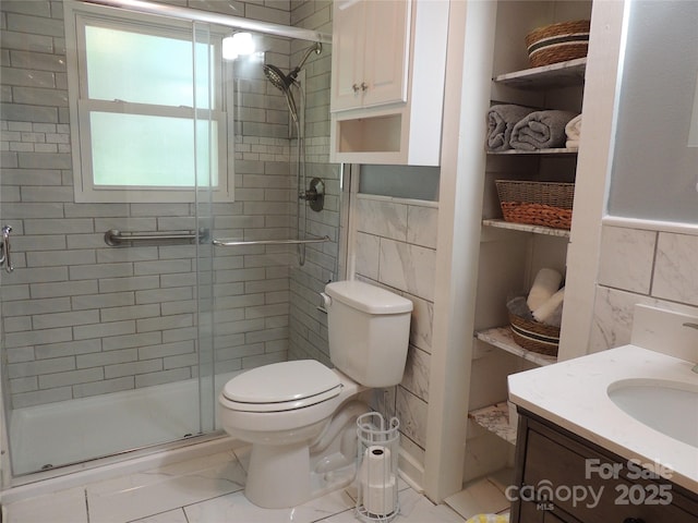 full bathroom featuring a stall shower, tile walls, marble finish floor, and toilet
