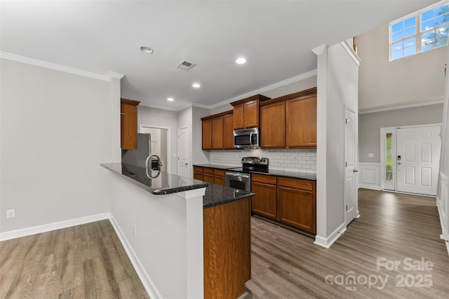 8505 Loxton Cir, Charlotte, NC 28214 - kitchen featuring dark wood-style flooring, decorative backsplash, visible vents, and appliances with stainless steel finishes