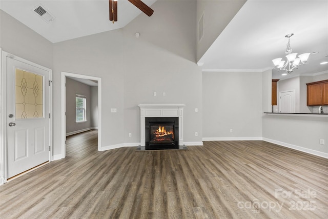 8505 Loxton Cir, Charlotte, NC 28214 - unfurnished living room featuring ceiling fan with notable chandelier, wood finished floors, visible vents, baseboards, and a glass covered fireplace