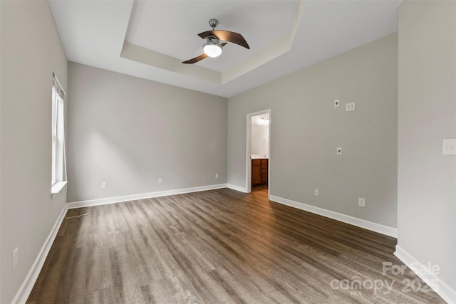 8505 Loxton Cir, Charlotte, NC 28214 - spare room featuring ceiling fan, a raised ceiling, baseboards, and dark wood-style floors