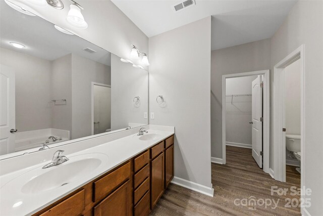 8505 Loxton Cir, Charlotte, NC 28214 - bathroom with a sink, toilet, visible vents, and wood finished floors