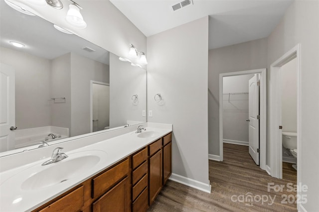 8505 Loxton Cir, Charlotte, NC 28214 - bathroom with a sink, toilet, visible vents, and wood finished floors