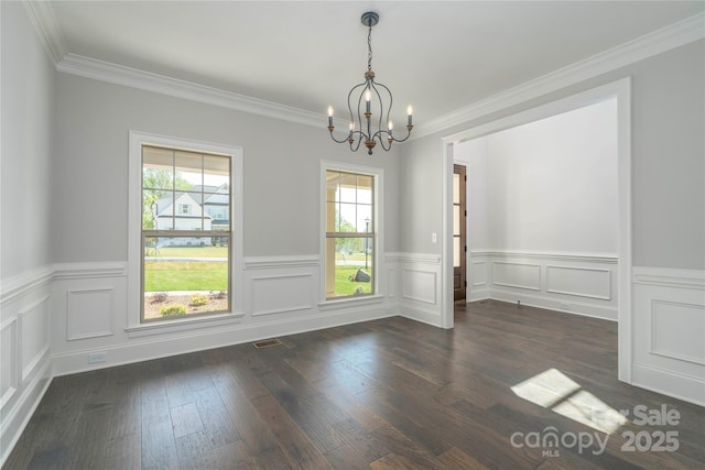 unfurnished dining area featuring a notable chandelier, dark wood finished floors, visible vents, wainscoting, and ornamental molding