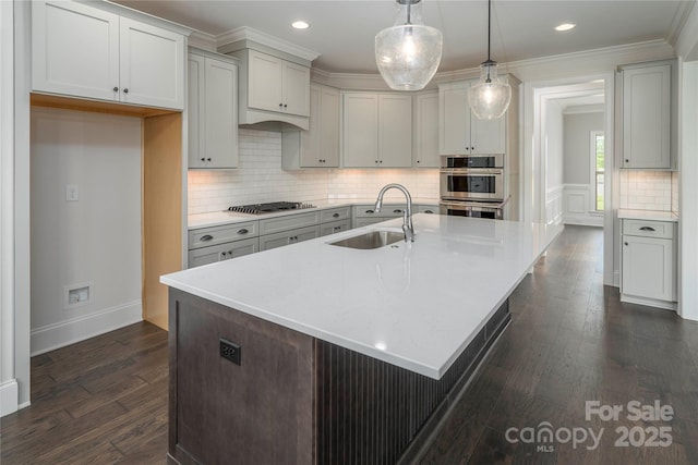 kitchen featuring a sink, stainless steel appliances, backsplash, light countertops, and dark wood-style floors