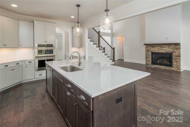 kitchen featuring backsplash, light countertops, stainless steel appliances, and a sink