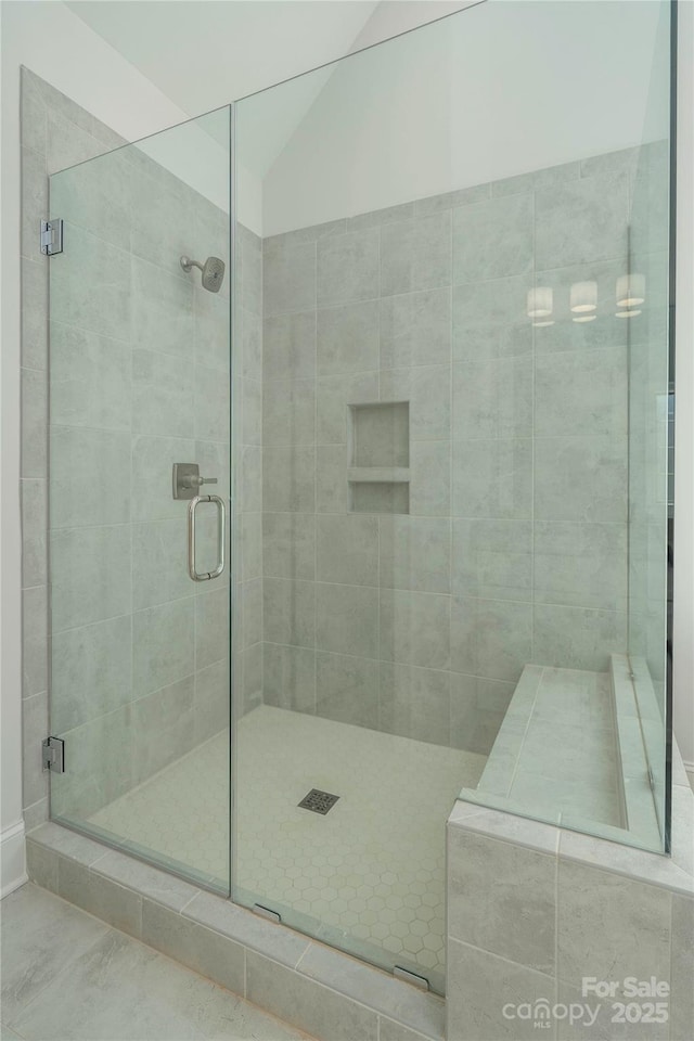 bathroom with vaulted ceiling and a stall shower
