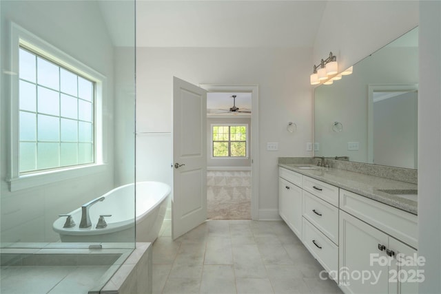 bathroom featuring lofted ceiling, tile patterned flooring, a ceiling fan, a freestanding bath, and double vanity