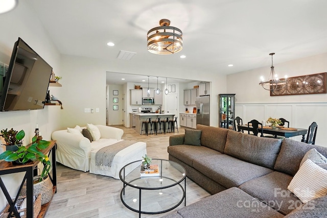12021 Basking Dr, Charlotte, NC 28214 - living room featuring a chandelier, light wood-type flooring, and recessed lighting