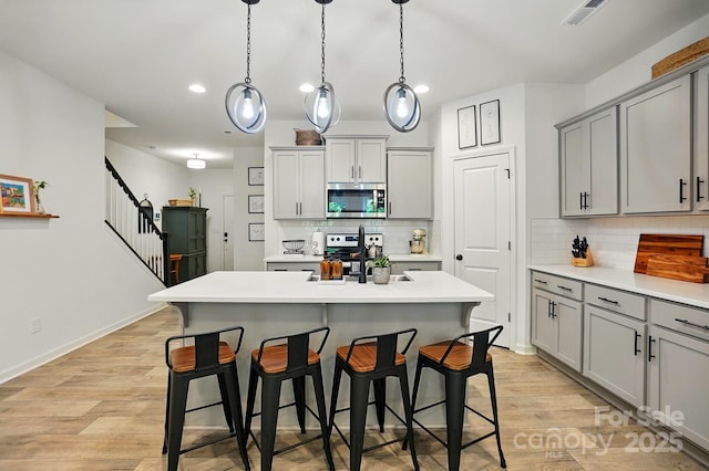 12021 Basking Dr, Charlotte, NC 28214 - kitchen with gray cabinetry, appliances with stainless steel finishes, a sink, light countertops, and recessed lighting