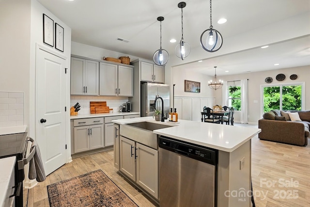 12021 Basking Dr, Charlotte, NC 28214 - kitchen with stainless steel appliances, gray cabinets, a sink, light wood-type flooring, and light countertops