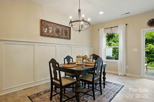 12021 Basking Dr, Charlotte, NC 28214 - dining area featuring a chandelier, a decorative wall, light wood finished floors, a wainscoted wall, and recessed lighting