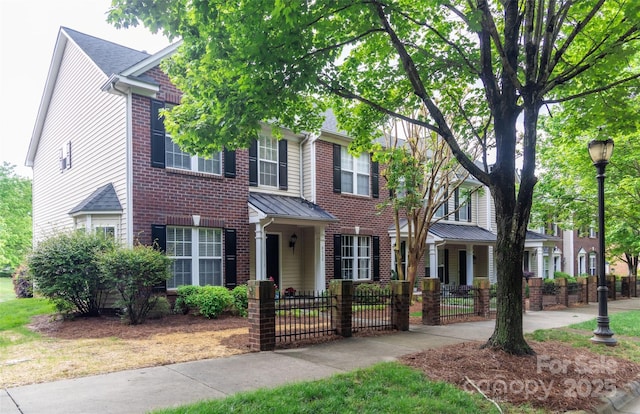 view of front of property with a fenced front yard and brick siding