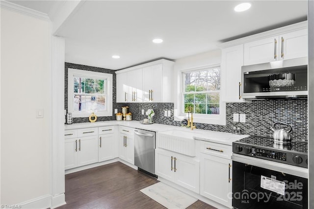 900 Gales Ave, Winston Salem, NC 27103 - kitchen featuring crown molding, light stone countertops, appliances with stainless steel finishes, and decorative backsplash