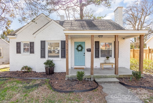 3141 Mathis Dr, Charlotte, NC 28208 - bungalow-style home with a porch, brick siding, and a chimney