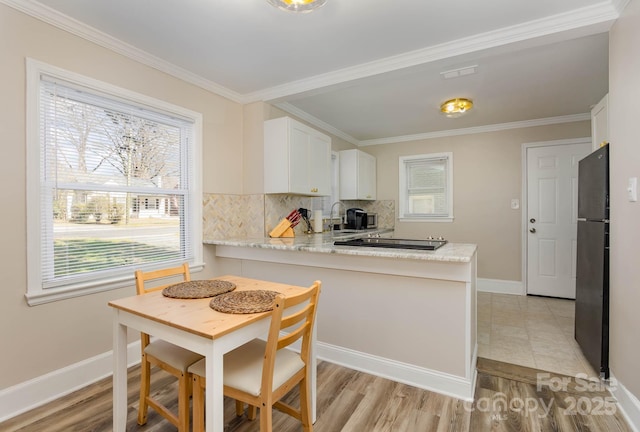 3141 Mathis Dr, Charlotte, NC 28208 - kitchen featuring ornamental molding, a healthy amount of sunlight, baseboards, and black appliances