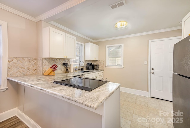 3141 Mathis Dr, Charlotte, NC 28208 - kitchen featuring baseboards, visible vents, a sink, decorative backsplash, and appliances with stainless steel finishes