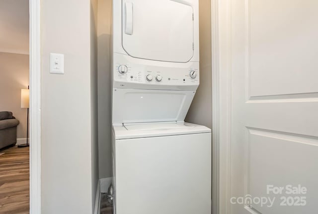 3141 Mathis Dr, Charlotte, NC 28208 - clothes washing area featuring stacked washing maching and dryer, crown molding, laundry area, and wood finished floors