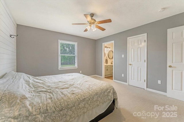 bedroom featuring carpet floors, baseboards, ensuite bath, and ceiling fan