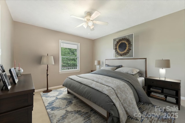 carpeted bedroom featuring baseboards and a ceiling fan