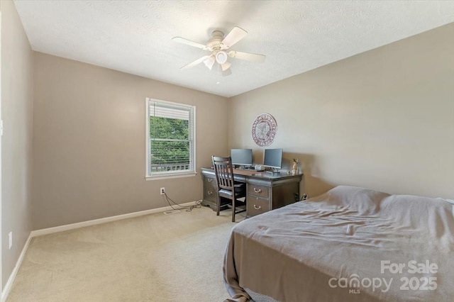 carpeted bedroom featuring baseboards, ceiling fan, and a textured ceiling