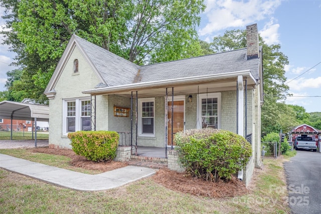 813 S Ridge Ave, Kannapolis, NC 28083 - view of front of home with a detached carport, a chimney, a porch, and fence